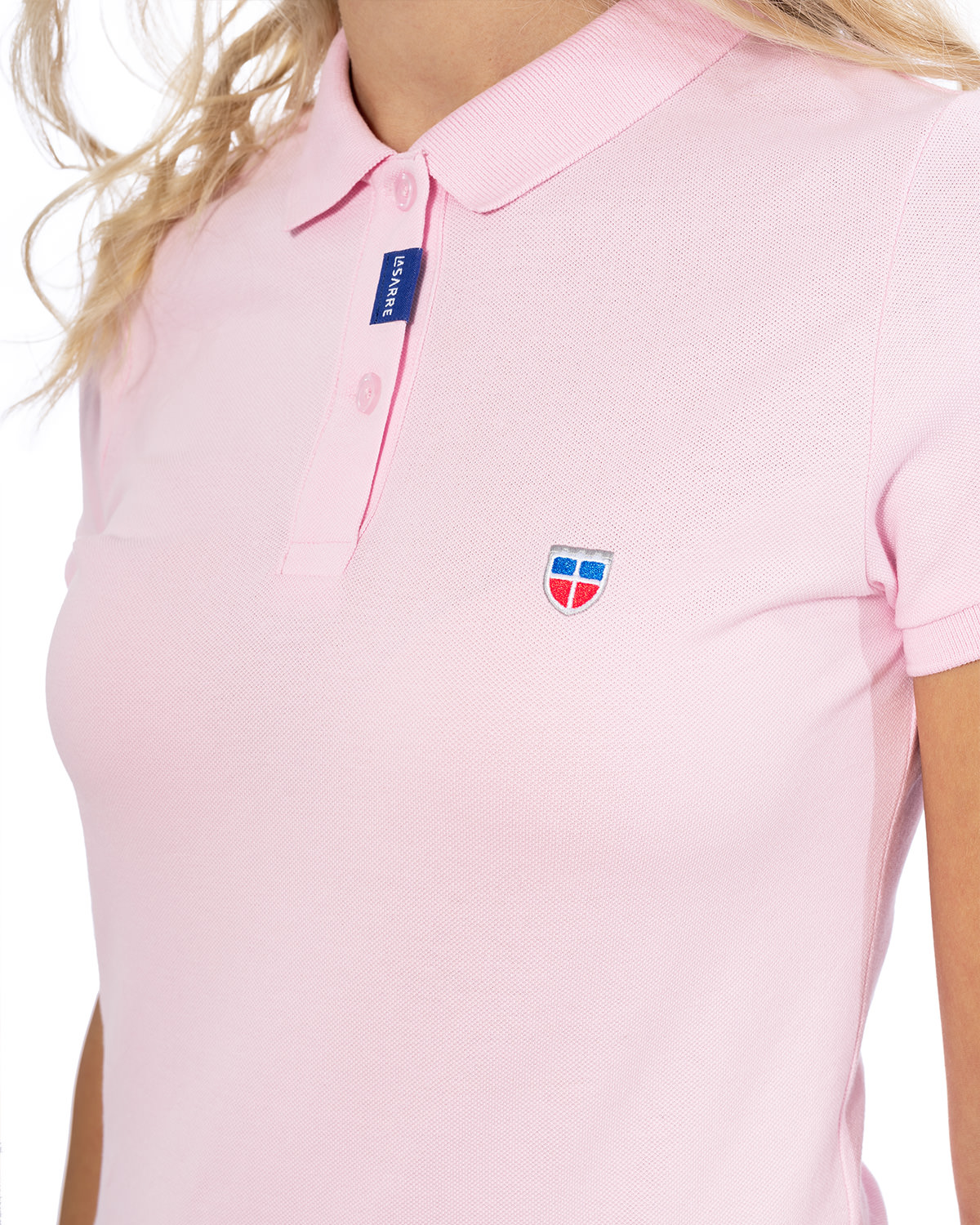 Vorder-Ansicht des hochwertig bestickten LA SARRE Frauen Polo Shirt in der besonderen Farbe Rosé von der Saarland Marke Lasarre mit LASARRE Wappen in Blau, Weiß, Rot auf der linken Brust und dem blauen LASARRE Markenzeichen an der Knopfleiste