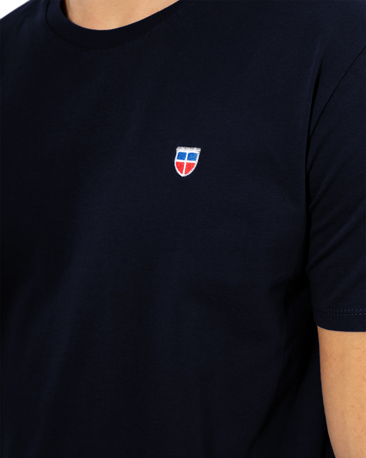 Seiten-Ansicht des hochwertig bestickten Männer T-Shirt „PAUL“ in der Farbe Navy-Blau von der Saarland Marke Lasarre mit Logo-Stickerei von dem LASARRE-Wappen in Blau, Weiß, Rot auf der linken Brust und dem blauen LASARRE Markenzeichen am Saum