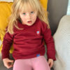 Unser Model Selma ist 3 Jahre alt und trägt Unser Saarland-Sweatshirt Tilda für Mädchen in Bordeaux.