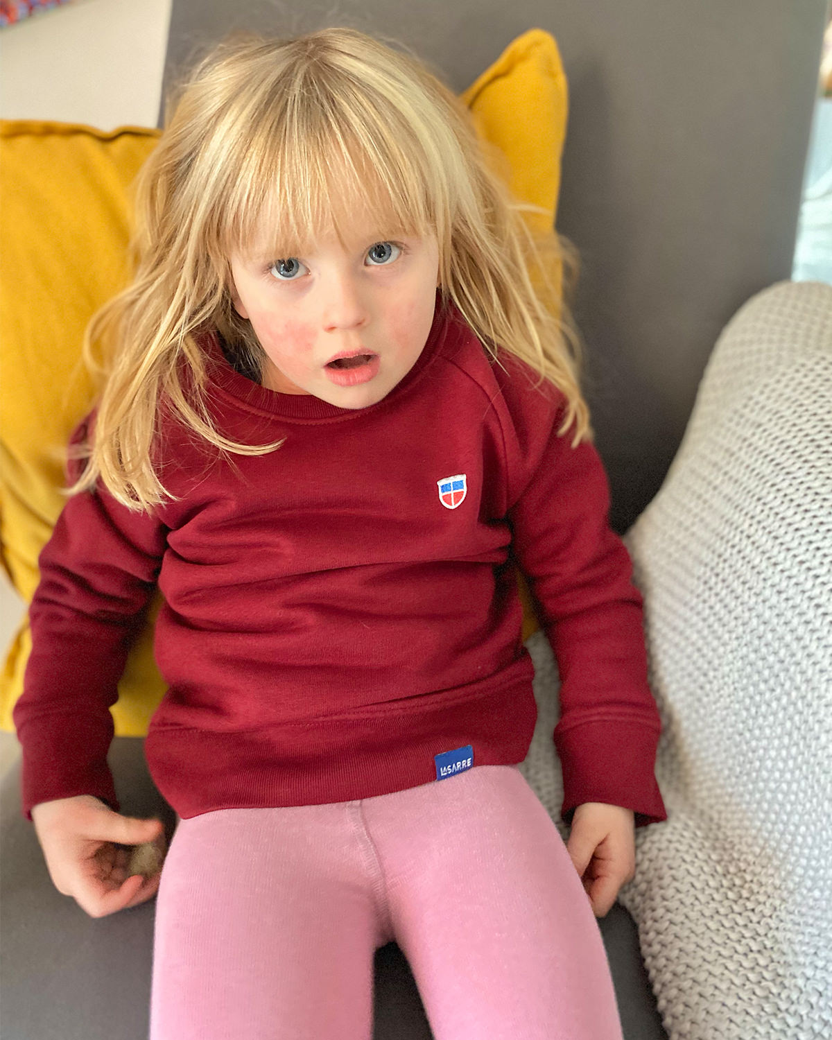 Unser Model Selma ist 3 Jahre alt und trägt Unser Saarland-Sweatshirt Tilda für Mädchen in Bordeaux.