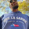 Saarland Geschenk VIVE LA SARRE Hoodie. Djimi präsentiert uns das Modell Adrian in der Farbe Kobalt. Die Perspektive zeigt die Besonderheit des Druckes, der wie ein dicker weißer Schaum auf dem Stoff liegt.